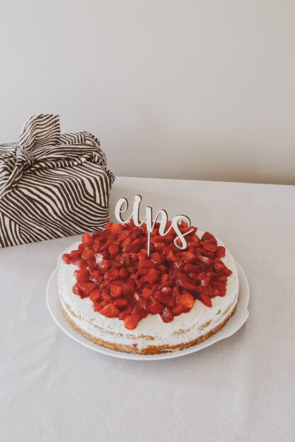 Auf diesem Bild sieht man einen Cake Topper mit einer eins.