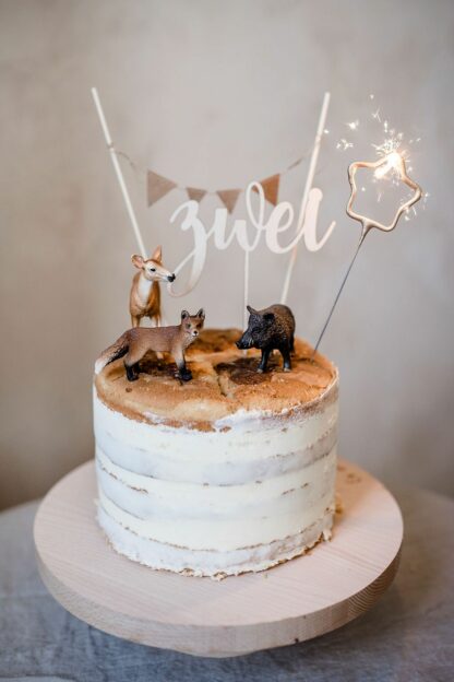 Auf diesem Bild sieht man einen Kuchen mit Schleich Tieren und einer zwei als Cake Topper.