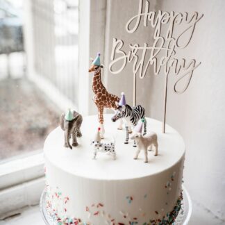 Auf diesem Bild sieht man einen Happy Birthday Cake Topper in einer Torte.