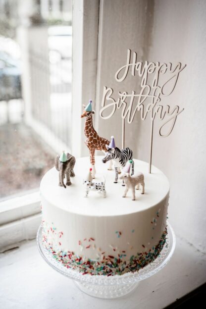 Auf diesem Bild sieht man einen Happy Birthday Cake Topper in einer Torte.