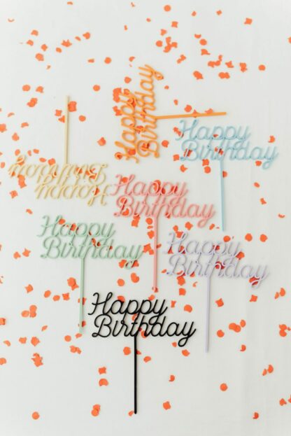 Auf diesem Bild sieht man bunte Happy Birthda Cake Topper.