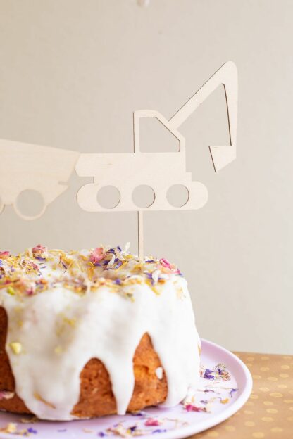 Auf diesem Bild sieht man einen Kuchen mit einem Bagger als Cake Topper.