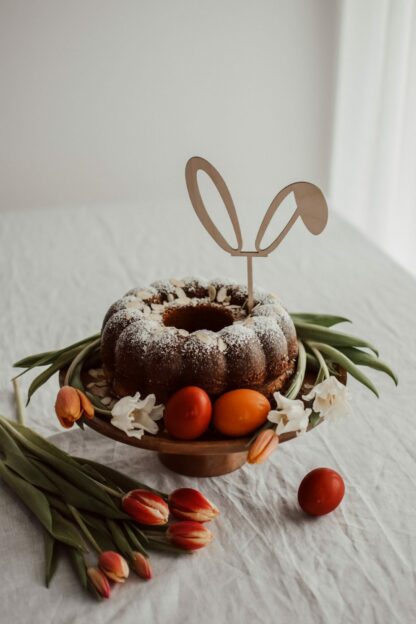 Auf diesem Bild siehst du eine Torte mit einem Cake Topper in Firm von Hasenohren.