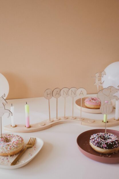 Auf diesem Bild sieht man einen dekorierten Geburtstagstisch mit einem personalisierten Geburtstagskranz.