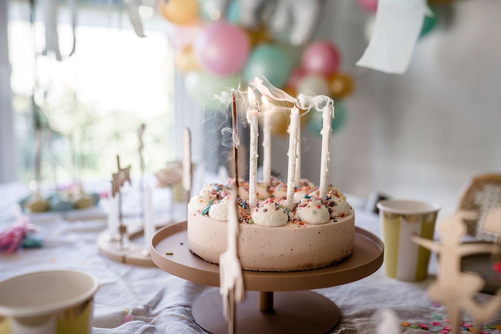 Auf diesem Bild sieht man einen Geburtstagstorte auf der Kerzen ausgepustet wurden.