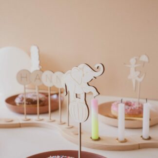 Auf diesem Bild sieht man einen Donut und einen Cake Topper Zirkus Elefanten.