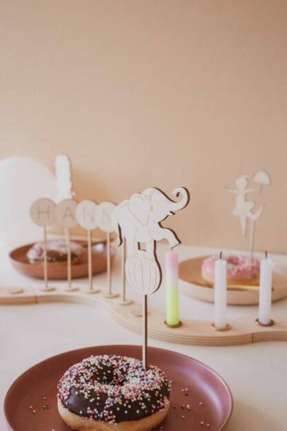 Auf diesem Bild sieht man einen Donut und einen Cake Topper Zirkus Elefanten.