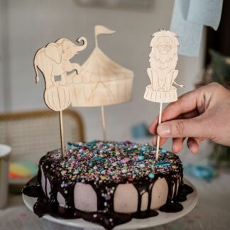 Auf diesem Bild sieht man eine Geburtstagstorte mit einem Cake Topper aus Holz in Form eines Löwens.