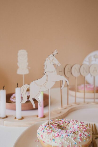 Auf diesem Bild sieht man einen Cake Topper aus Holz in Form von einem Zirkuspferd.