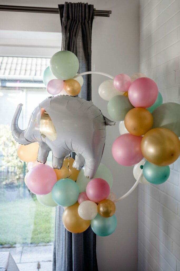 Auf diesem Bild sieht man einen einen mit bunten Luftballons und einem Elefanten-Ballon dekorierten Reifen.