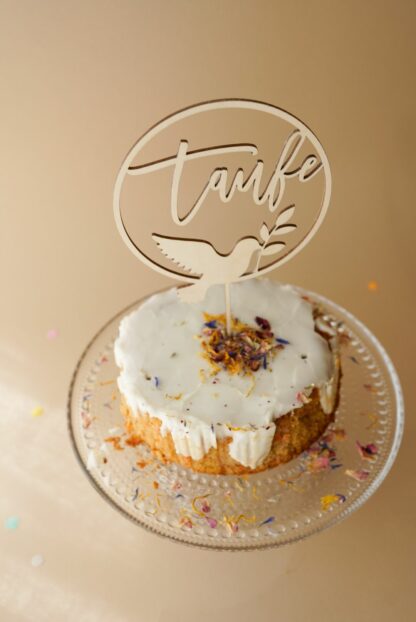 Auf diesem Bild sieht man eine Torte zur Taufe mit einem Cake Topper zur Taufe mit einer Taube.