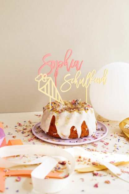 Auf diesem Bild sieht man einen Kuchen von Kuchentratsch der mit Cake Toppern zur Einschulung dekoriert ist.