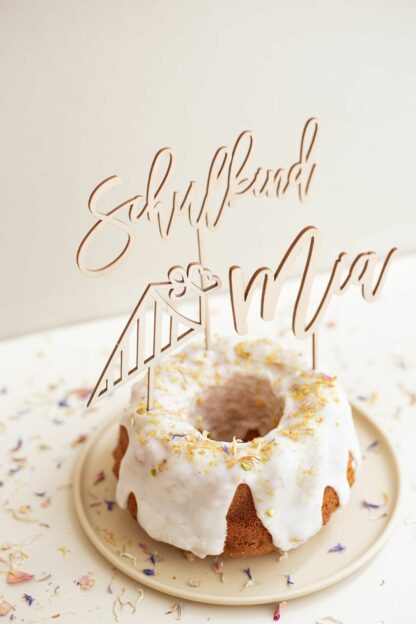 Auf diesem Bild sieht man ein Cake Topper Set zur Einschulung aus Holz in einem Kuchen.