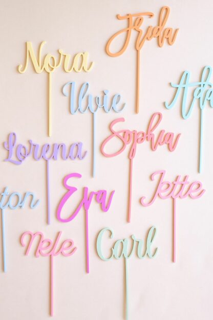Auf diesem Bild sieht man verschiedene Name in unterschiedlichen Pastelltönen als Stecker für den Geburtstagskranz.
