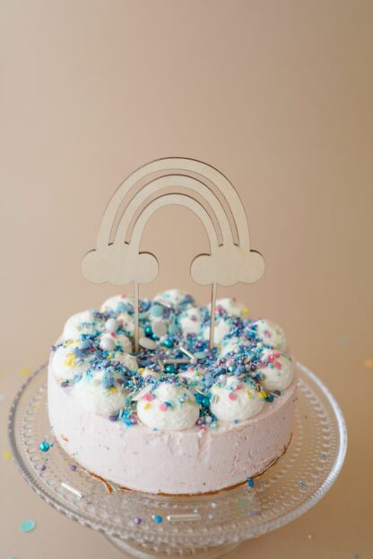 Auf diesem Bild sieht man einen Cake Topper Regenbogen aus Holz in einer Benjamin Blümchen Torte von Coppenrath und Wiese mit Super Streuseln dekoriert.