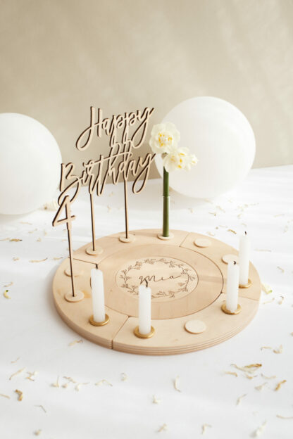 Auf diesem Bild sieht man einen Geburtstagskranz mit einem Mädchen Namen und Kerzen dekoriert.
