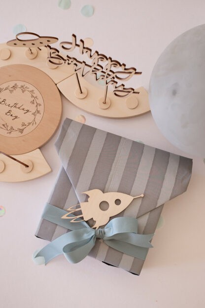 Auf diesem Bild sieht man einen Geburtstagstisch mit einem Happy Birthday Stecker aus Holz und Geschenken.