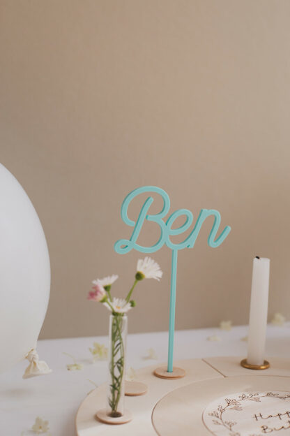 Auf diesem Bild sieht man einen Geburtstagskranz für einen Jungen mit blauen Steckern mit dem Namen Ben.