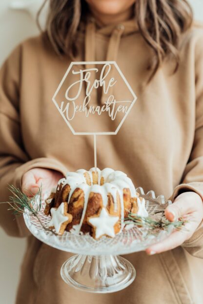 Auf diesem Bild sieht man einen Kuchen mit einem Frohe Weihnachten Cake Topper.