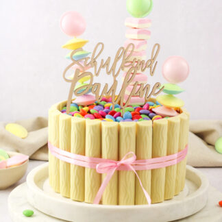 Auf diesem Bild sieht man einen Cake Topper mit einem Namen und einem mit Schulkind in einer Torte zur Einschulung.
