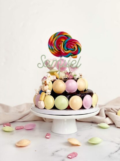 Auf diesem Bild sieht man einen Kuchen mit einem grünen personalisierten Cake Topper mit dem Namen Samuel.