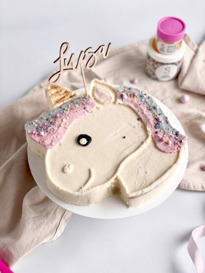 Auf diesem Bild sieht man einen personalisierten Cake Topper in einem Einhornkuchen.