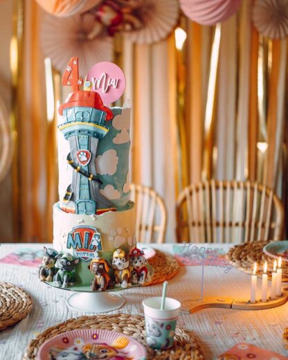 Auf diesem Bild sieht man eine Paw Patrol Torte die mit einem rosa personalisierten Cake Topper dekoriert wurde.