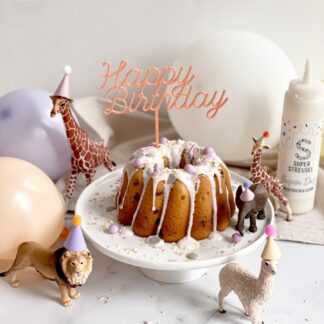 Auf diesem Bild sieht man einen Geburtstagskuchen mit Schleich Tieren und einem Happy Birthday Cake Topper dekoriert.