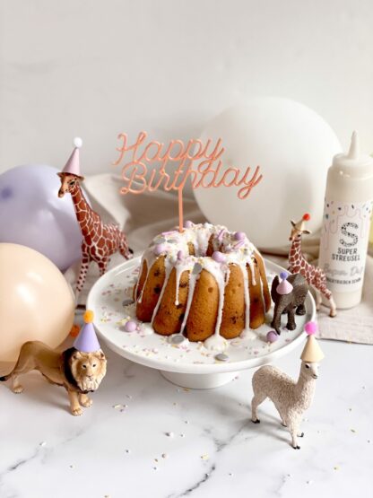 Auf diesem Bild sieht man einen Geburtstagskuchen mit Schleich Tieren und einem Happy Birthday Cake Topper dekoriert.