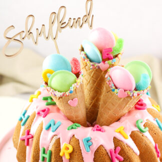Auf diesem Bild sieht man einen Kuchenidee zur Einschulung mit einem Cake Topper Schulkind.