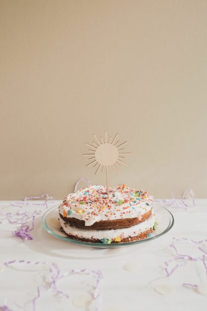 Kuchenstecker Sonne im Kuchen mit Streuseln dekoriert.