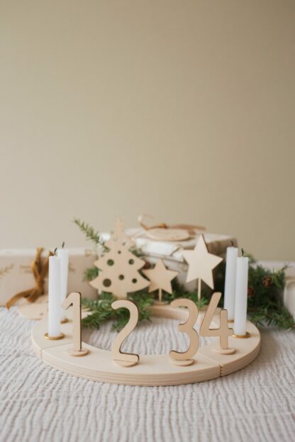 Zeitloser Adventskranz aus Holz mit Kerze und Steckfiguren.