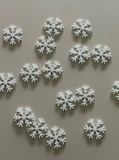 Weiße Schneeflocken als Konfetti als Tischdeko für Weihnachten.