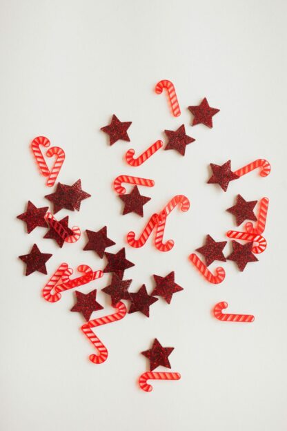 Sterne in rot und Zuckerstangen als moderne Tischdeko zu Weihnachten in Form von Konfetti.