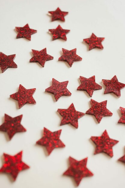 Sterne in rot Glitzer als moderne Tischdeko zu Weihnachten in Form von Konfetti.