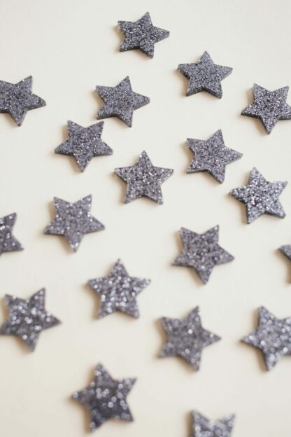 Sterne in silber Glitzer als moderne Tischdeko zu Weihnachten in Form von Konfetti.