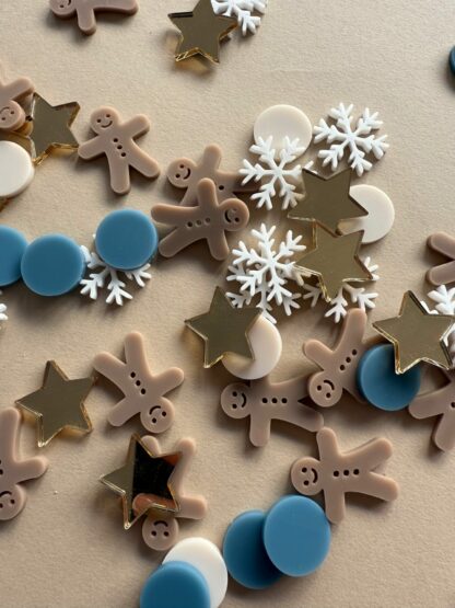 Tischdeko zu Weihnachten Konfetti in Form von Lebkuchenmännern, Sternen und Schneeflocken.