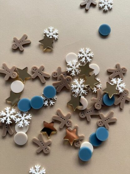 Tischdeko zu Weihnachten Konfetti in Form von Lebkuchenmännern, Sternen und Schneeflocken.