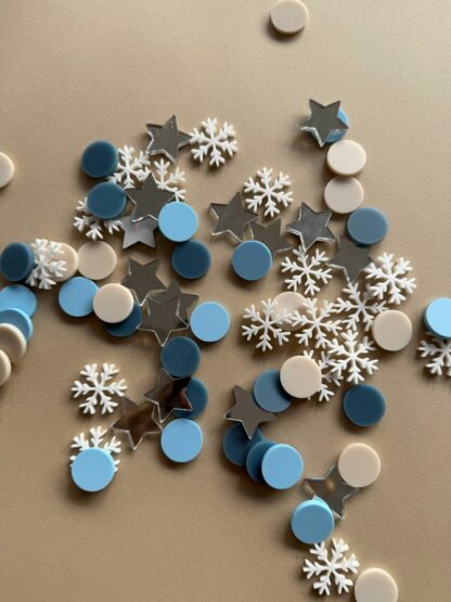 Tischdeko zu Weihnachten Konfetti in Form von Sternen und Schneeflocken.